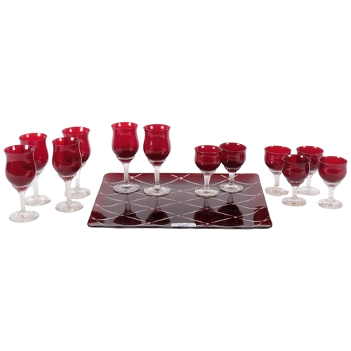 565 - A suite of 6 ruby Sherry glasses, and 6 ruby glass liqueur shot glasses, on an Art Deco style ruby g... 