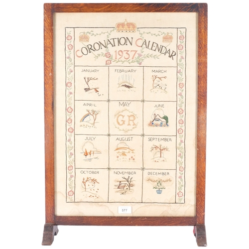 577 - A 1937 Coronation calendar needlework, in the form of a fire screen, wooden frame with glass panel, ... 