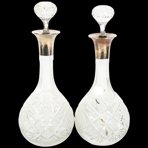 867 - A pair of cut-glass decanters with silver collars, H32cm