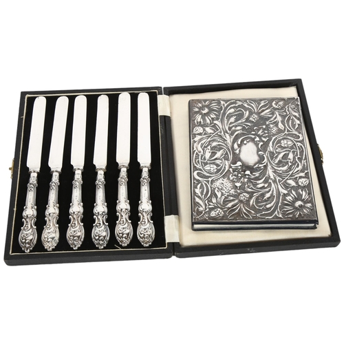 884 - A cased set of silver-handled tea knives, and a notebook with an embossed silver cover