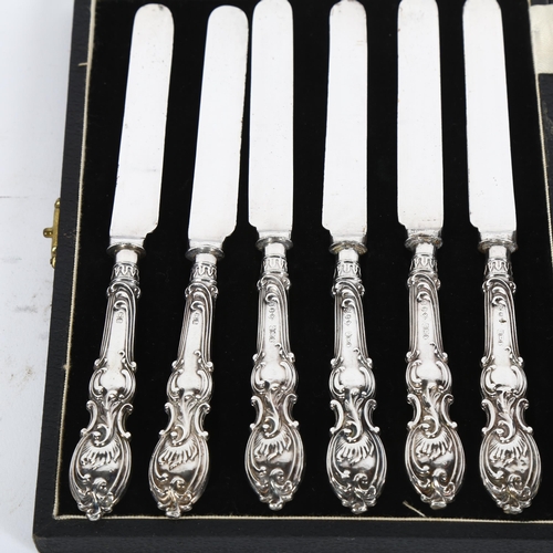 884 - A cased set of silver-handled tea knives, and a notebook with an embossed silver cover