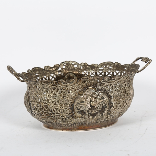 896 - An ornate Victorian silver 2-handled table basket, with allover embossed and pierced decoration, W17... 