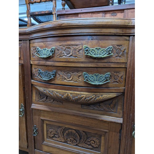 2134 - A mahogany Art Nouveau style sideboard, with four drawers, three cupboards and carved foliate decora... 