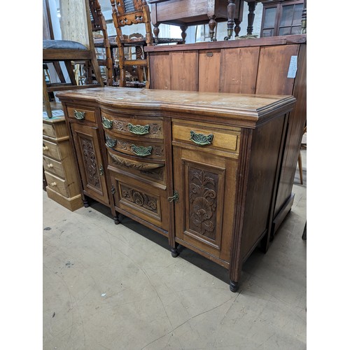 2134 - A mahogany Art Nouveau style sideboard, with four drawers, three cupboards and carved foliate decora... 