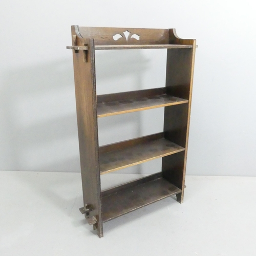 2105 - An Arts & Crafts style oak open bookcase, of pegged construction, with pierced decoration and three ... 