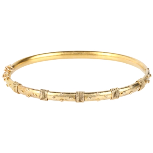 1104 - A Victorian 15ct gold Etruscan Revival hinged bangle, circa 1880, with applied rope twist and bead d... 