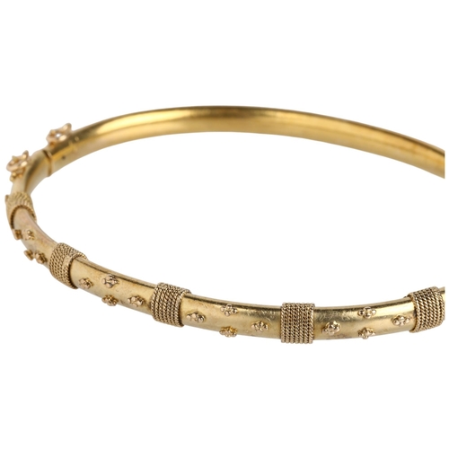 1104 - A Victorian 15ct gold Etruscan Revival hinged bangle, circa 1880, with applied rope twist and bead d... 