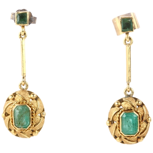 1115 - A pair of emerald drop earrings, late 20th century, rub-over set with octagonal and square step-cut ... 