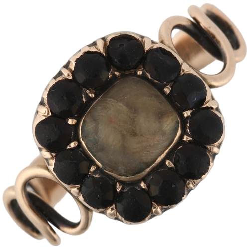 1126 - A Georgian hairwork and jet mourning ring, circa 1820, the central woven hair panel beneath convex g... 