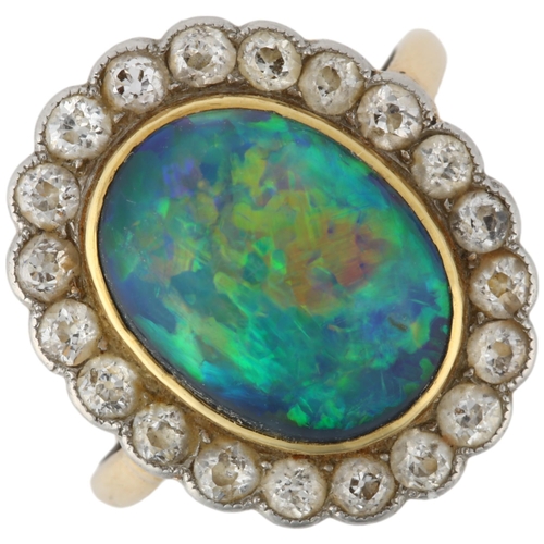 1130 - A black opal and diamond oval cluster ring, mid-20th century, rub-over set with 2.5ct oval cabochon ... 