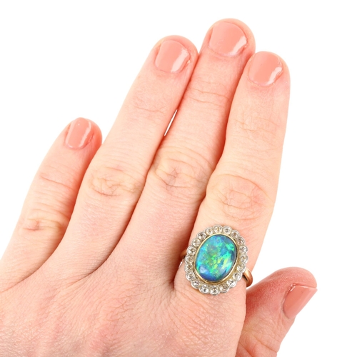 1130 - A black opal and diamond oval cluster ring, mid-20th century, rub-over set with 2.5ct oval cabochon ... 