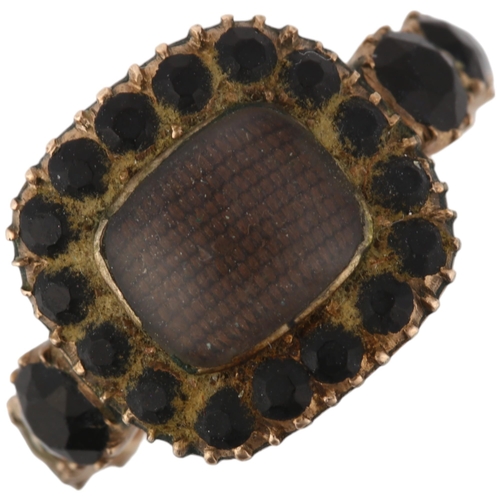 1179 - A Georgian jet mourning ring, circa 1820, the central moire silk panel beneath convex glass, within ... 