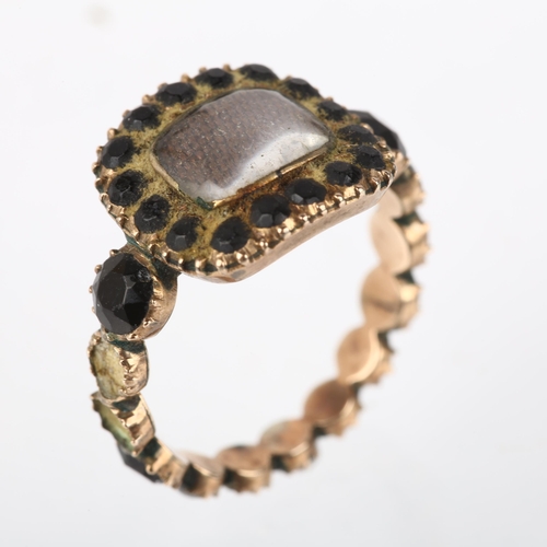 1179 - A Georgian jet mourning ring, circa 1820, the central moire silk panel beneath convex glass, within ... 