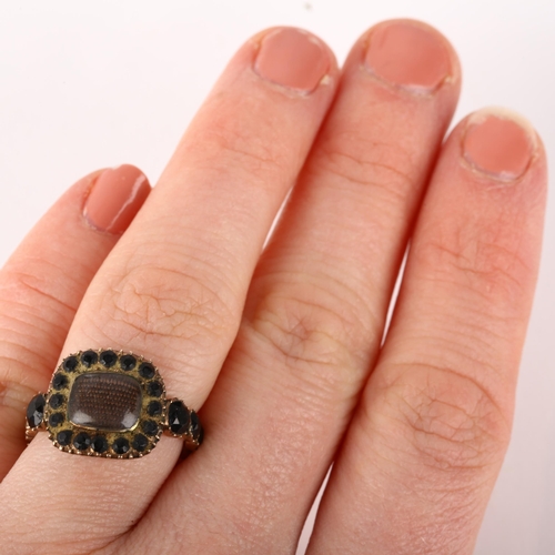 1179 - A Georgian jet mourning ring, circa 1820, the central moire silk panel beneath convex glass, within ... 