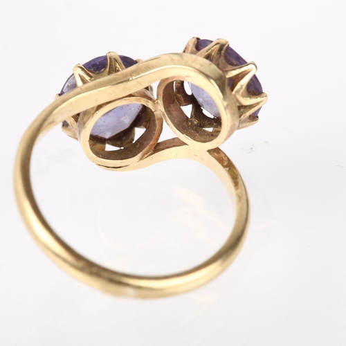 1190 - A late 20th century two stone synthetic sapphire crossover ring, claw set with 8.5mm sapphires, appa... 