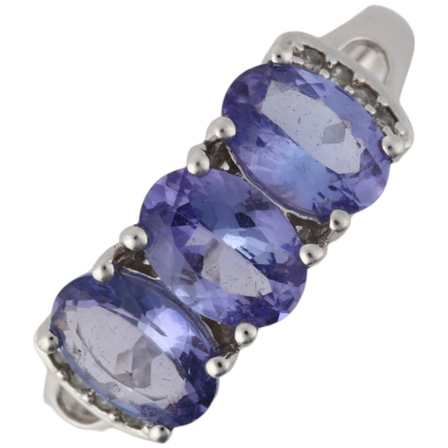 1198 - A modern 9ct white gold tanzanite and diamond dress ring, claw set with oval mixed-cut tanzanites an... 