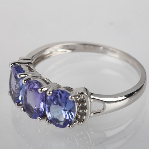 1198 - A modern 9ct white gold tanzanite and diamond dress ring, claw set with oval mixed-cut tanzanites an... 