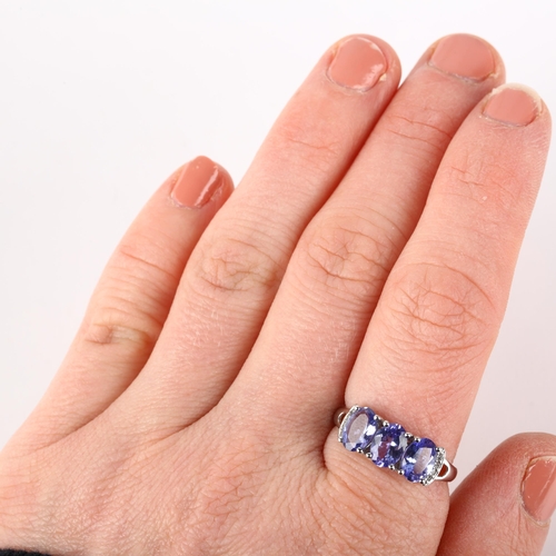 1198 - A modern 9ct white gold tanzanite and diamond dress ring, claw set with oval mixed-cut tanzanites an... 