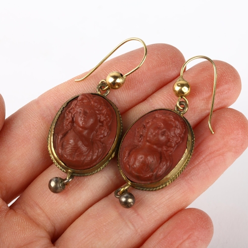 1264 - A pair of Victorian Revival composition cameo earrings, circa 1940s, brass rope twist frames with re... 