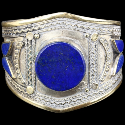 1363 - An Afghan Ethnic lapis lazuli cuff bangle, apparently unmarked, setting height 56.2mm, internal circ... 