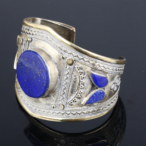 1363 - An Afghan Ethnic lapis lazuli cuff bangle, apparently unmarked, setting height 56.2mm, internal circ... 