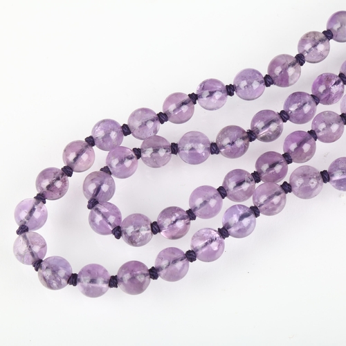 1365 - A Chinese amethyst bead necklace, each 10mm bead individually knotted, with silver-gilt filigree cla... 