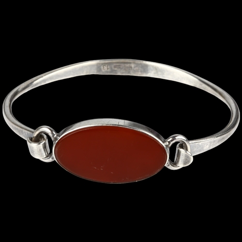 1377 - NIELS ERIK FROM - a Danish modernist sterling silver and carnelian torque bangle, model no. 13, sett... 