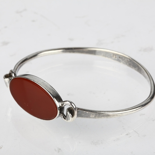 1377 - NIELS ERIK FROM - a Danish modernist sterling silver and carnelian torque bangle, model no. 13, sett... 