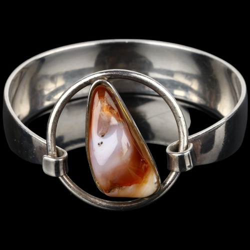 1386 - NIELS ERIK FROM - a Danish modernist sterling silver and agate openwork torque bangle, setting heigh... 