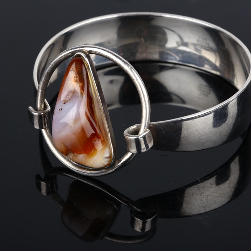 1386 - NIELS ERIK FROM - a Danish modernist sterling silver and agate openwork torque bangle, setting heigh... 