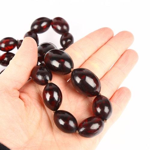 1419 - A graduated single-strand Cherry Bakelite bead necklace, beads measure 27.0 - 15.7mm, necklace 80cm,... 