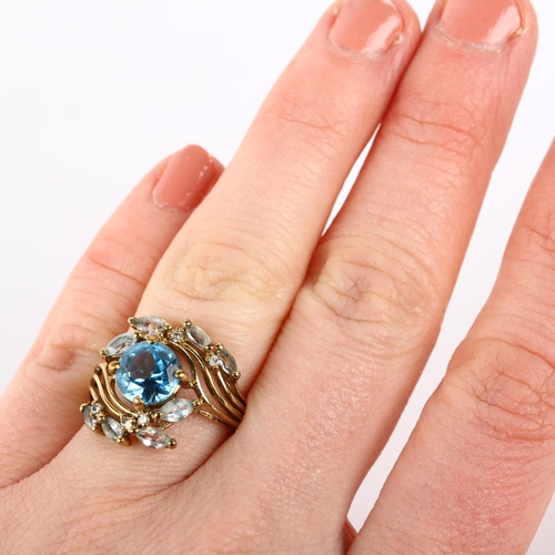 1274 - A modern 9ct gold blue topaz and diamond floral crossover ring, setting height 16.7mm, size K, 4g