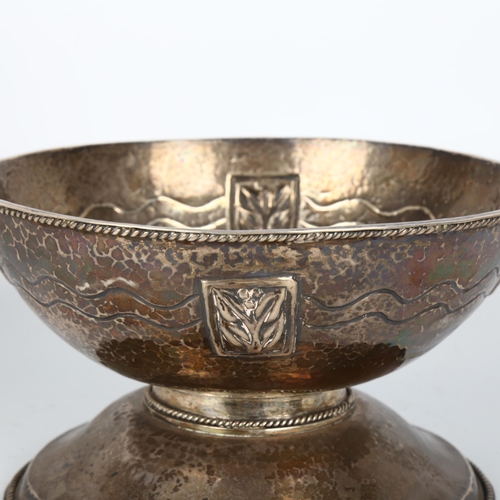 1455 - An Arts and Crafts white metal pedestal bowl, allover planished decoration with relief embossed flor... 