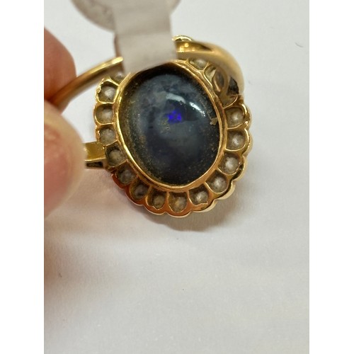 1130 - A black opal and diamond oval cluster ring, mid-20th century, rub-over set with 2.5ct oval cabochon ... 