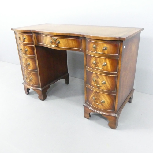 2117 - An early 20th century style serpentine fronted kneehole writing desk, with tooled and embossed leath... 