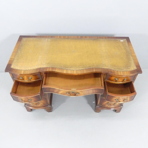 2117 - An early 20th century style serpentine fronted kneehole writing desk, with tooled and embossed leath... 