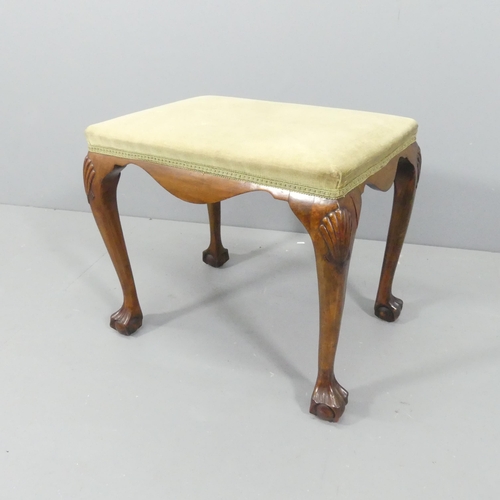 2124 - A continental walnut and upholstered footstool, with appllied carved decoration and raised on cabrio... 