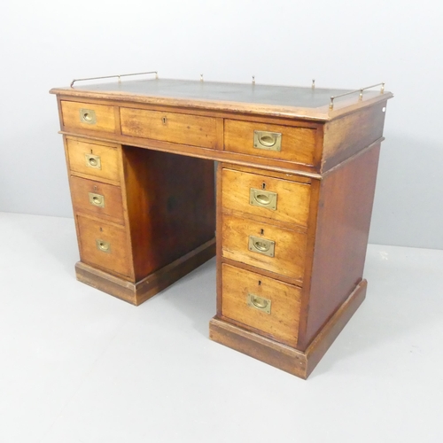 2137 - An antique mahogany campaign style twin pedestal writing desk, with seven drawers and brass handles.