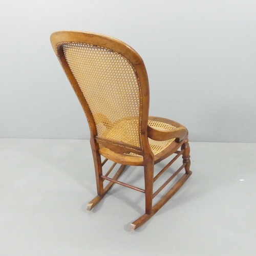 2159 - An early 20th century continental oak rocking chair, with cane back and seat panels. Impressed B to ... 