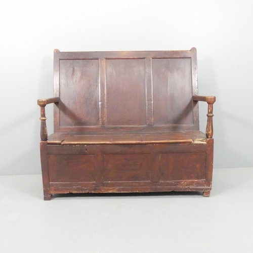 2184 - An antique stained pine settle, with panelled back and lifting seats. Overall 129x118x55cm, seat 116... 