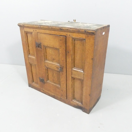 2195 - An antique panelled oak hanging cabinet with shelf fitted interior. 62x56x23cm.