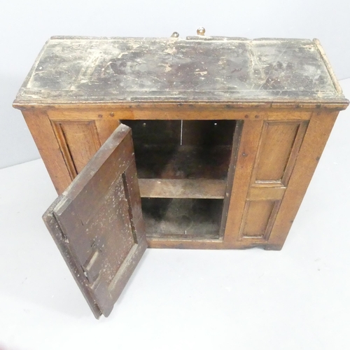 2195 - An antique panelled oak hanging cabinet with shelf fitted interior. 62x56x23cm.