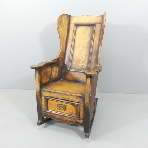 2196 - An 18th / 19th century pine wingback lambing rocking chair, the single drawer with campaign style ha... 