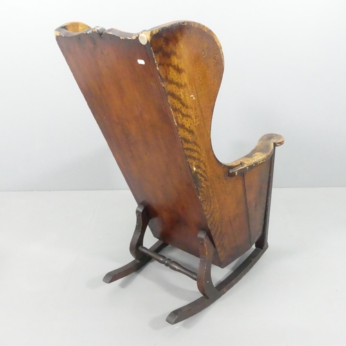 2196 - An 18th / 19th century pine wingback lambing rocking chair, the single drawer with campaign style ha... 