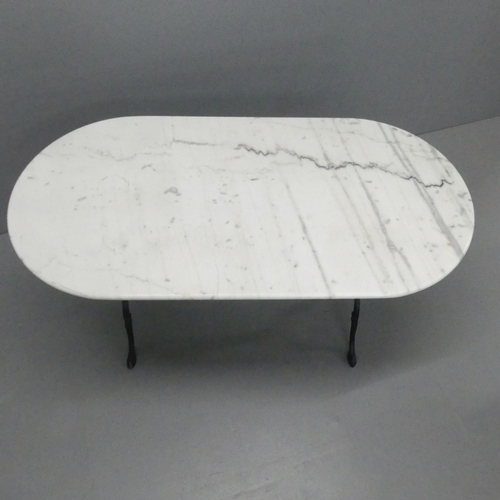 2088 - An oval marble topped table on cast iron base. 121x74x60cm.