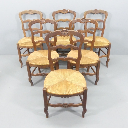 2220 - A set of six French oak rush-seated ladderback dining chairs with carved decoration.