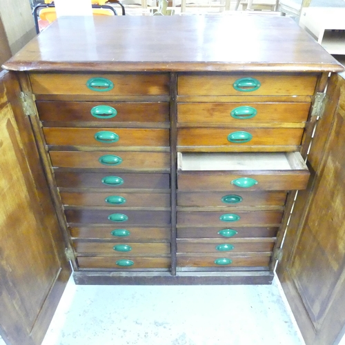 2561 - A pitch pine two-door cabinet fitted with twenty filing drawers. 112x123x65cm.