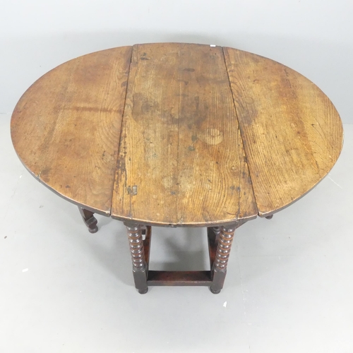 2573 - An antique oak oval gate-leg table, with bobbin turned legs. 106x73x43cm (opening to 125cm).