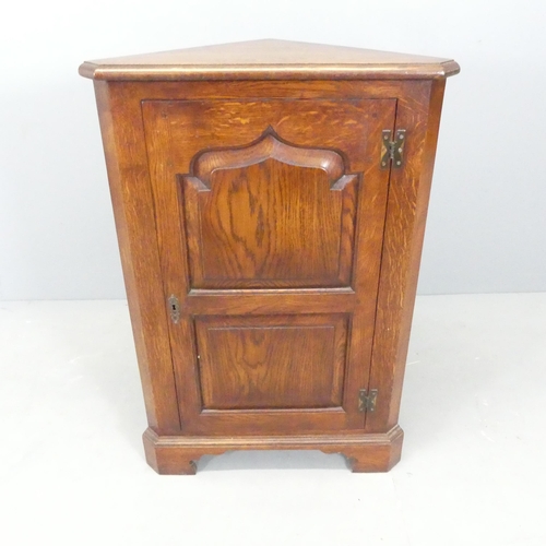 2574 - A Georgian style panelled oak corner cupboard. 60x88x34cm.