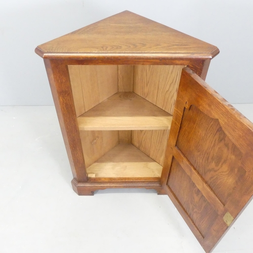 2574 - A Georgian style panelled oak corner cupboard. 60x88x34cm.